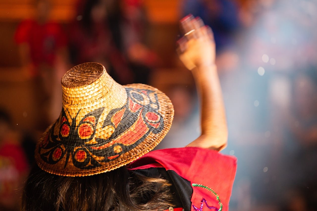 Image of a woman in traditional attire, with raised arm.