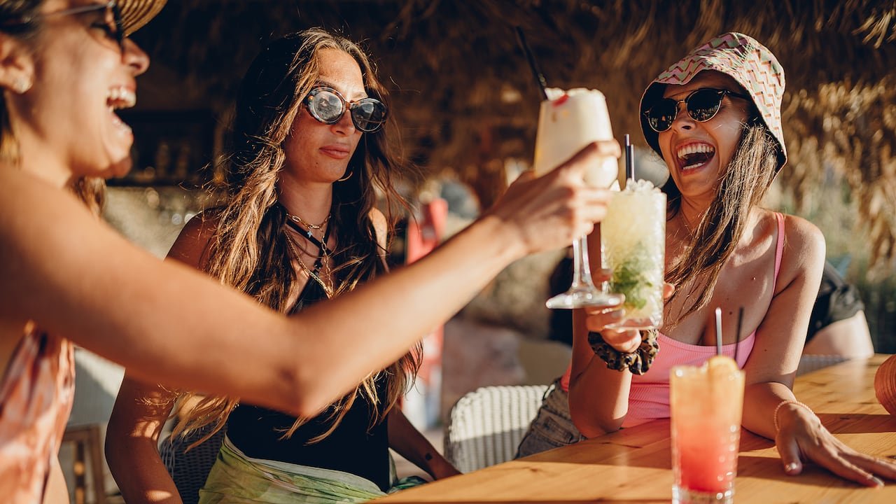 Friends enjoying time at a beach bar, with a concerned woman in the center.
